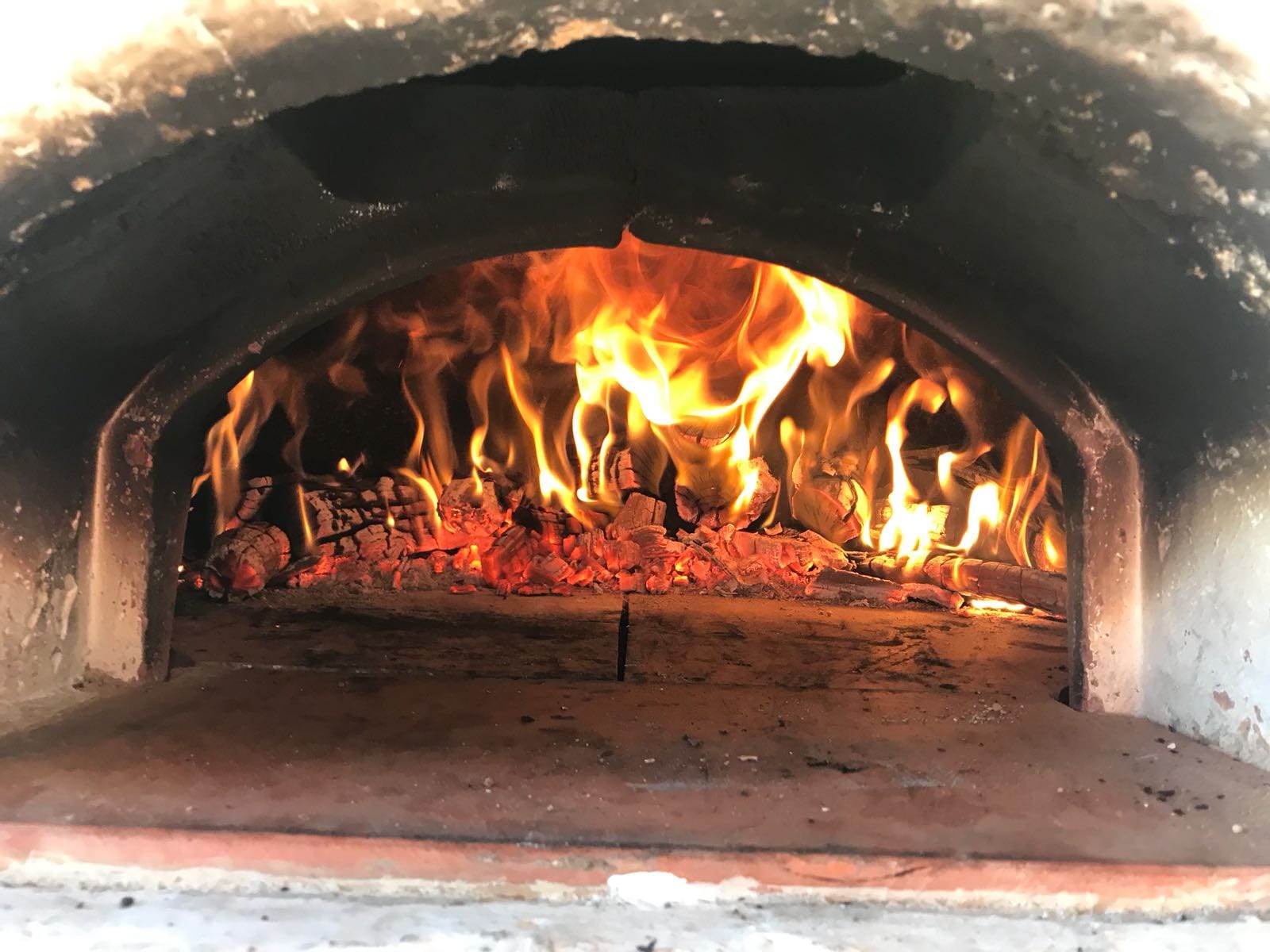 Korsischer Holzofen mit Feuer am Abend