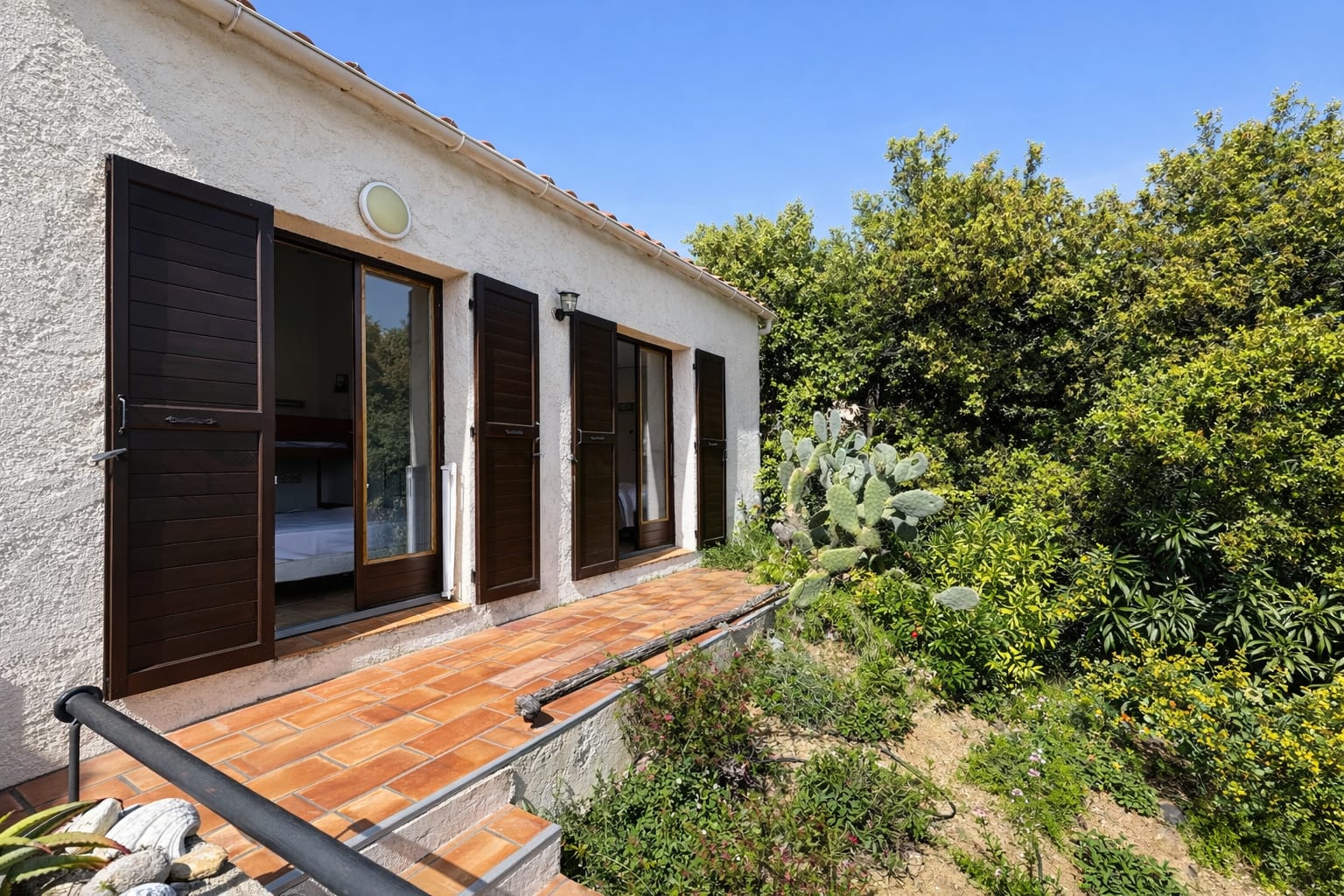 Außenfassade des Studios mit eigenen Eingangstüren und Fensterläden