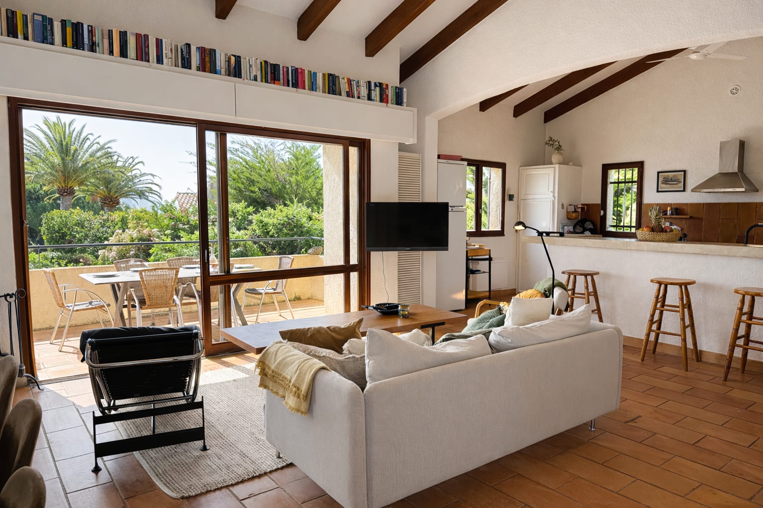 Wohnzimmer mit Sofa, Tresen und Blick zur Terrasse